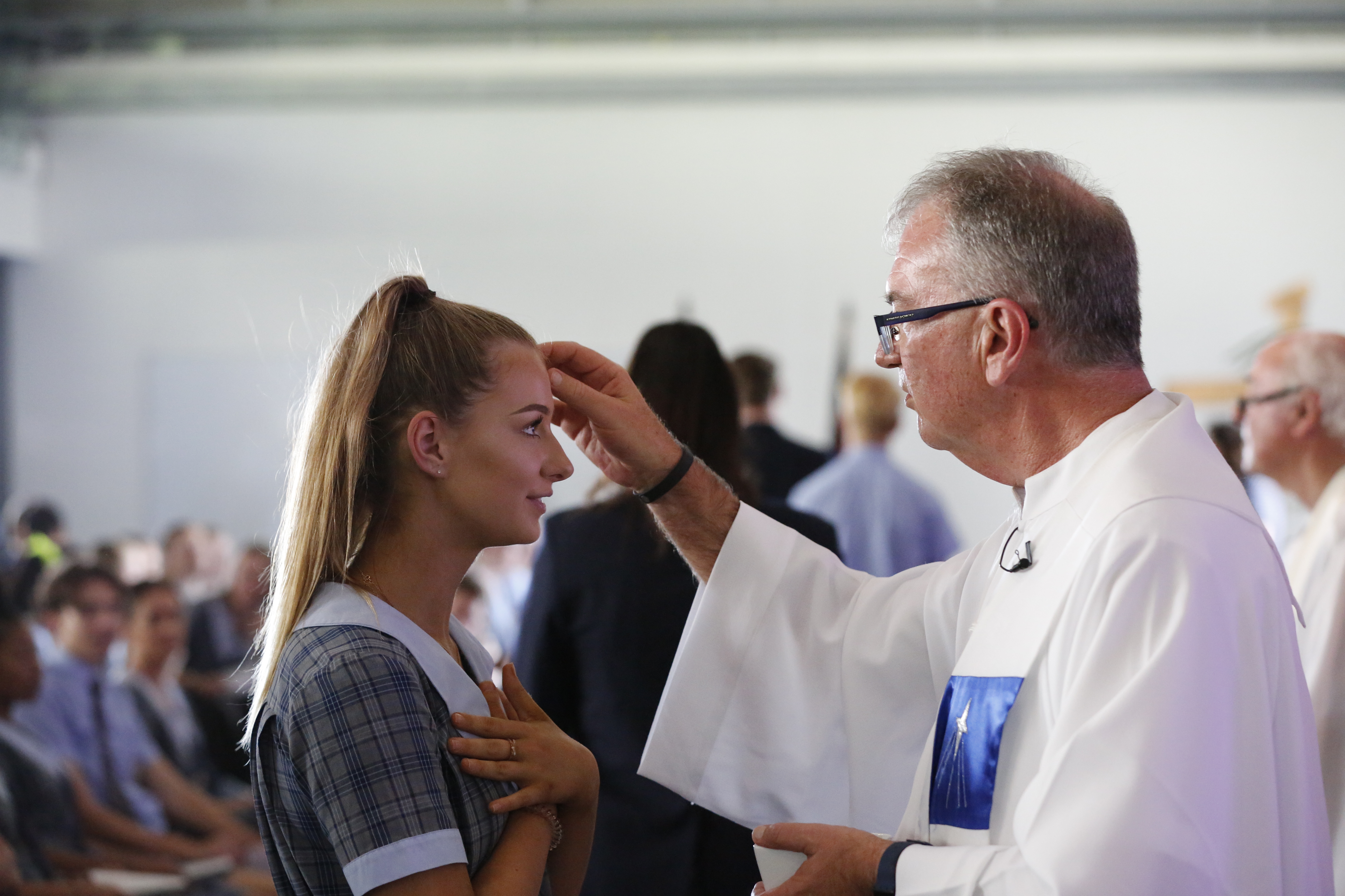 Priest marking a student’s forehead during a liturgy