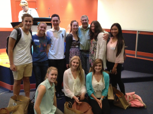 Group of students posing together in an indoor presentation room
